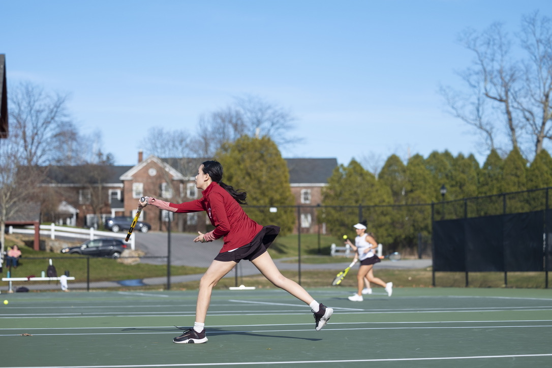 Bella lunging for a forehand during a varsity tennis match